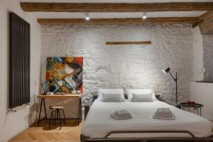 ein Schlafzimmer mit einem großen Bett und einer Steinmauer in der Unterkunft Apartments Trieste Centro I S. Michele 2 in Triest