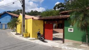 una moto estacionada frente a un edificio colorido en Casa Recanto Azul, en Paraty