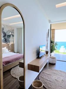Schlafzimmer mit einem Bett und einem Spiegel in der Unterkunft Pink Sunset Beachfront Exotic Room in Batroun 