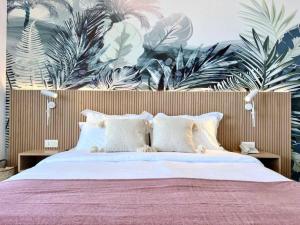1 dormitorio con 1 cama grande con plantas en la pared en Pink Sunset Beachfront Exotic Room in Batroun, 