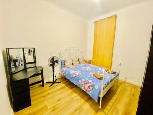 a bedroom with a bed and a desk in it at Two Bedroom house on Ground Floor in London in London