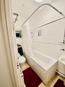 ein Badezimmer mit einer Badewanne, einem WC und einem Waschbecken in der Unterkunft Two Bedroom house on Ground Floor in London in London