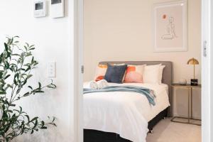 a bedroom with a bed with orange and blue pillows at Modern 1BR Apt in Southbank #Australia108#AU4408 in Melbourne