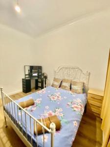 ein Schlafzimmer mit einem Bett mit einer blauen Decke mit Blumen in der Unterkunft Two Bedroom house on Ground Floor in London in London