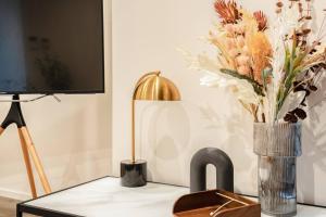 a table with a vase of flowers and a television at Modern 1BR Apt in Southbank #Australia108#AU4408 in Melbourne