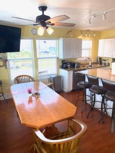 a kitchen with a wooden table with chairs and a counter at Amazing Sunsets bay view @The Villa at Copano Cove in Rockport