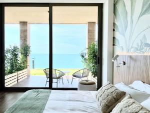 a bedroom with a bed and a view of the ocean at Banana Leaf Beachfront Exotic Room in Batroun 