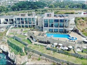 an aerial view of a resort with a swimming pool at Banana Leaf Beachfront Exotic Room in Batroun 
