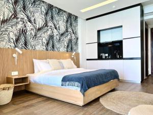 1 dormitorio con 1 cama y un mural en la pared en Indigo Jungle Beachfront Exotic Room in Batroun, 
