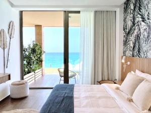 a bedroom with a bed and a view of the ocean at Indigo Jungle Beachfront Exotic Room in Batroun in Fghāl