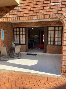 a patio with two chairs and a table in a brick building at Off-shore Guest house in Margate
