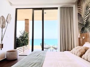 a bedroom with a bed and a view of the ocean at Wild Areca Beachfront Exotic Room in Batroun in Fghāl
