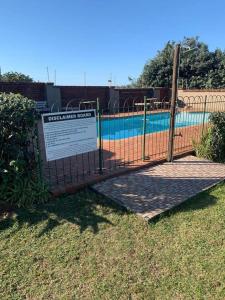 a gate with a sign in front of a pool at Off-shore Guest house in Margate