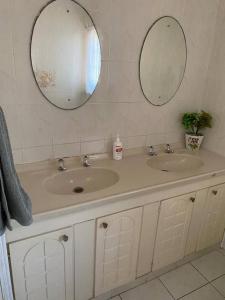 a bathroom with two sinks and two mirrors at Off-shore Guest house in Margate