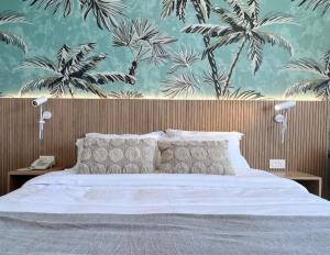 a bedroom with a large bed with a tropical wallpaper at Palm Paradise Beachfront Exotic Room in Batroun in Fghāl