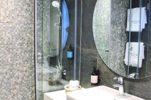 uma casa de banho com um chuveiro, um lavatório e um espelho. em Palm Paradise Beachfront Exotic Room in Batroun 