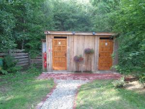 a wooden shed with two doors in a yard at Biwak u Gazdy in Gosprzydowa