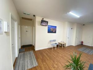 Habitación vacía con 2 sillas y TV en la pared en Rangers GuestHouse, en Glasgow
