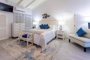 Dickenson Bay的住宿－Antigua Village- Villa Lilly 33B，一间卧室配有一张床、一把椅子和一张沙发