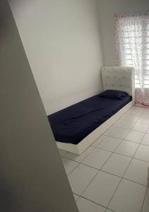 - une chambre avec un lit doté d'un matelas bleu et d'une fenêtre dans l'établissement D CAMYLIA PUTRAJAYA HOMESTAY, à Putrajaya