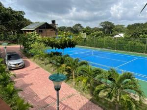 - un court de tennis avec une voiture garée à côté dans l'établissement Cabaña Higueron Tennis Club, à Turbaco