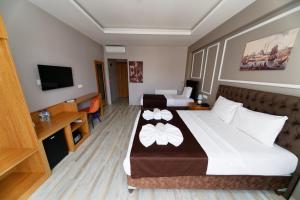HanPoint Boutique Hotel في إسطنبول: غرفه فندقيه سرير كبير وتلفزيون