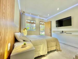 a bedroom with a bed and a tv on a wall at Estalagem Cachoeira do Pimenta in Cunha