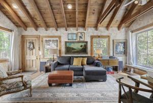 ein Wohnzimmer mit einem Sofa und einem Tisch in der Unterkunft Owl Pine Cabin on Strawberry Creek in Idyllwild