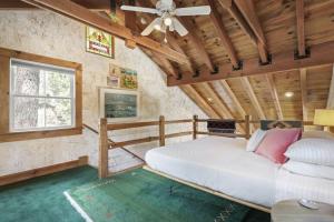 Schlafzimmer mit einem Bett und einem Deckenventilator in der Unterkunft Owl Pine Cabin on Strawberry Creek in Idyllwild