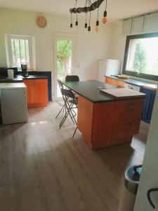 eine Küche mit orangefarbenen Schränken und einer schwarzen Arbeitsplatte in der Unterkunft Les combes in Montarnaud
