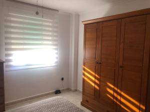 a bedroom with a wooden cabinet and a window at Paraíso in Cumbre del Sol