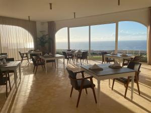 a restaurant with tables and chairs and a view of the ocean at Villa La Falaise in Oualidia