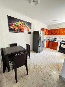 a kitchen with a table and a black refrigerator at Apartamento Vacacional Cartagena Colombia in Cartagena de Indias