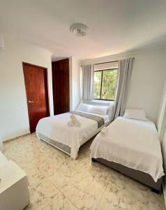 1 dormitorio con 2 camas y ventana en Apartamento Vacacional Cartagena Colombia, en Cartagena de Indias
