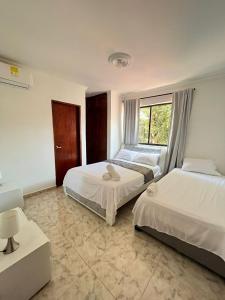 sypialnia z 2 łóżkami i oknem w obiekcie Apartamento Vacacional Cartagena Colombia w mieście Cartagena de Indias