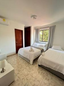 1 dormitorio con 2 camas y ventana en Apartamento Vacacional Cartagena Colombia, en Cartagena de Indias