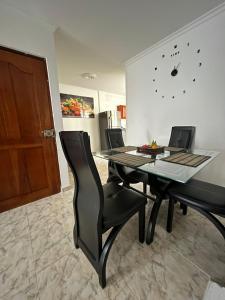 a dining room with a table and chairs and a clock at Apartamento Vacacional Cartagena Colombia Cerca Aeropuerto y Playa 2 in Cartagena de Indias