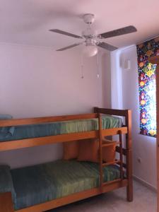 コンブレ・デル・ソルにあるParaísoの二段ベッド2台、シーリングファンが備わる客室です。
