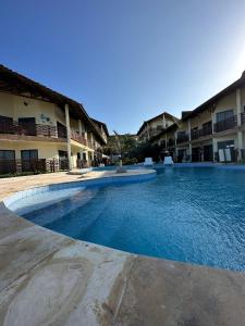 a large swimming pool in front of a building at Apto 2 quartos - Condomínio Frente Mar in Beberibe