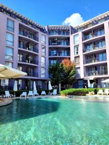a swimming pool in front of a building at Rainbow 3 Sunny Beach Topo Apartment in Sunny Beach