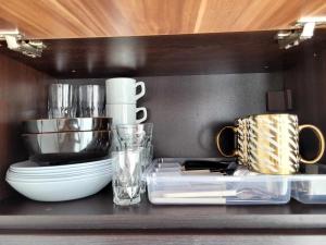 a kitchen counter with plates and cups on a shelf at Rainbow 3 Sunny Beach Topo Apartment in Sunny Beach