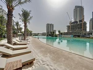 a large swimming pool with palm trees and buildings at Sunset at Creek Beach - Vacationer in Dubai