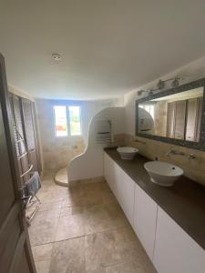 a bathroom with two sinks and a mirror at Le Hameau des vanades in Ampus