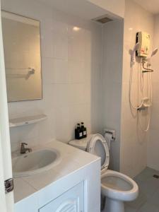 uma casa de banho com um lavatório, um WC e um espelho. em บ้านศรีแบริ่ง em Bangna