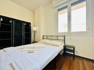 a white bed in a room with a window at Suite Galilei 159 - Sanremo in Sanremo