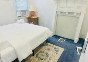 - une chambre avec un grand lit blanc et une fenêtre dans l'établissement Oui on Ludlow - Entire House and Private Rooms in University City, à Philadelphie