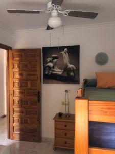 コンブレ・デル・ソルにあるParaísoのベッドルーム1室(ベッド1台付)が備わります。壁にスクーターの絵画が飾られています。