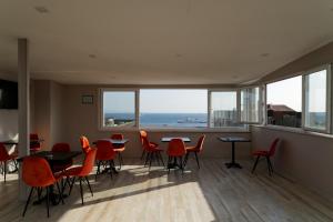 un comedor con sillas y mesas rojas y una gran ventana en HanPoint Boutique Hotel, en Estambul