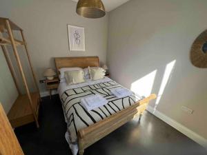 een slaapkamer met een bed met een zwart-wit dekbed bij Private garden oasis in central Bristol in Bristol