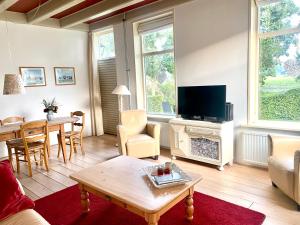 a living room with a couch and a table and a tv at Vakantiewoning Opa's Huisje in Ruinerwold